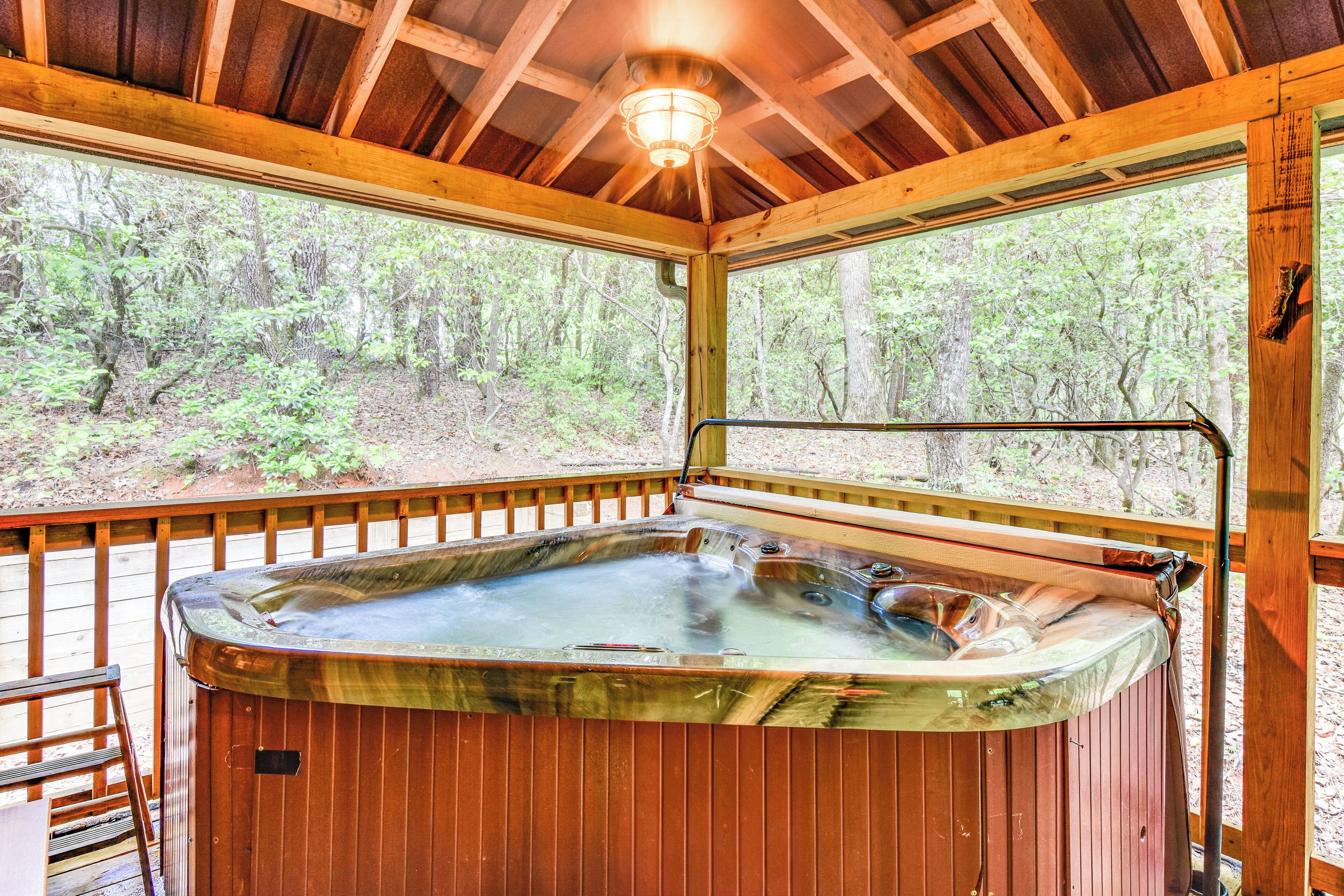 Un bain à remous dans un chalet en bois avec vue sur une forêt.