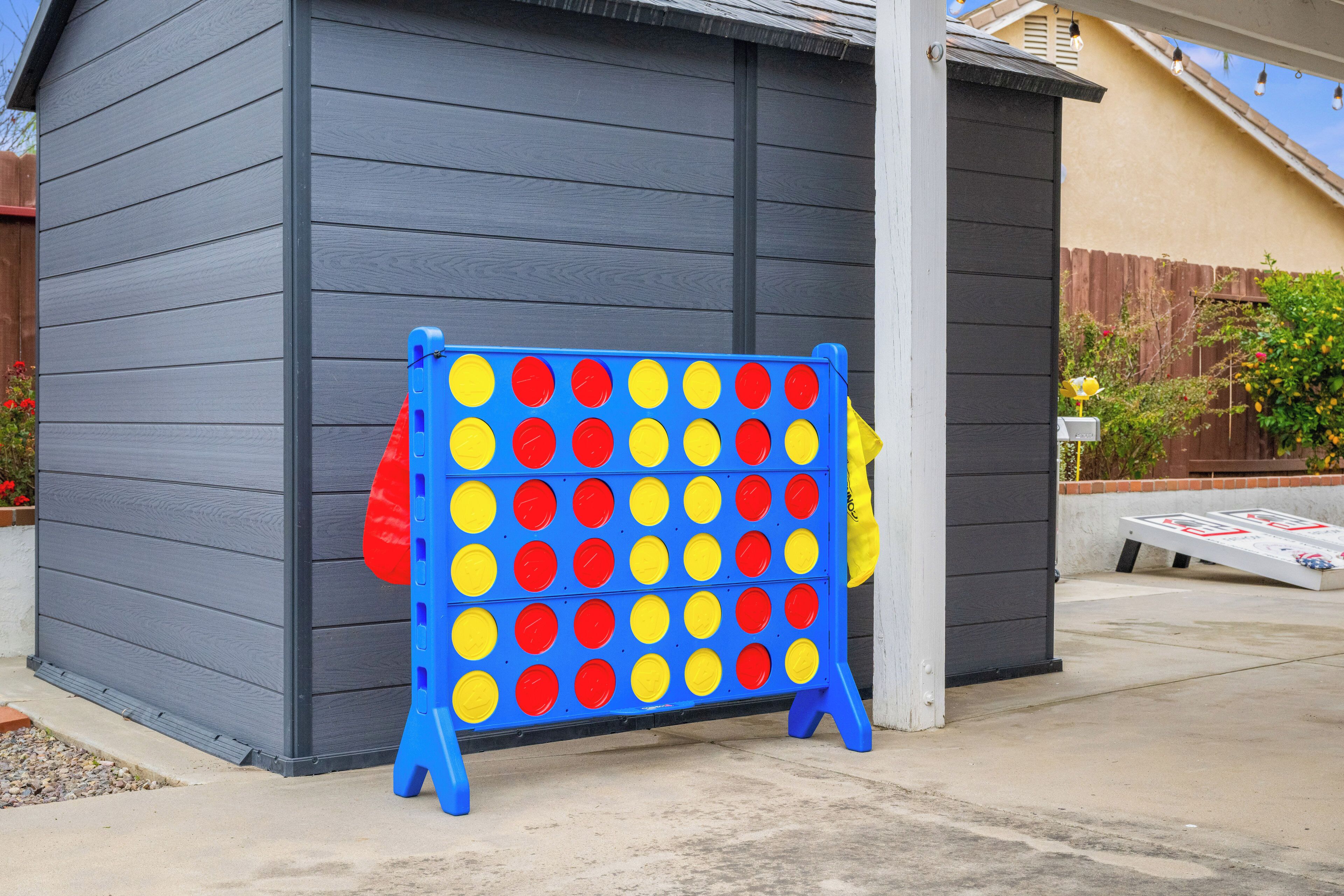 A blue and yellow board game set up against a gray building.