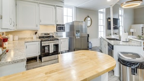 A modern kitchen with white cabinets, stainless steel appliances, and a wooden countertop. - Unique Church Turned Family Retreat: Relax & Enjoy (Alliance)