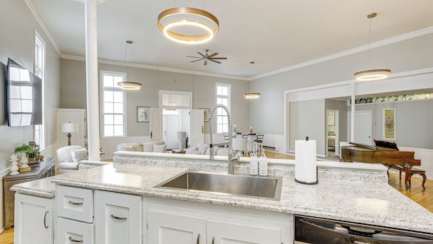 A spacious kitchen with granite countertops, a stainless steel sink, and a modern ceiling fan. - Unique Church Turned Family Retreat: Relax & Enjoy (Alliance)
