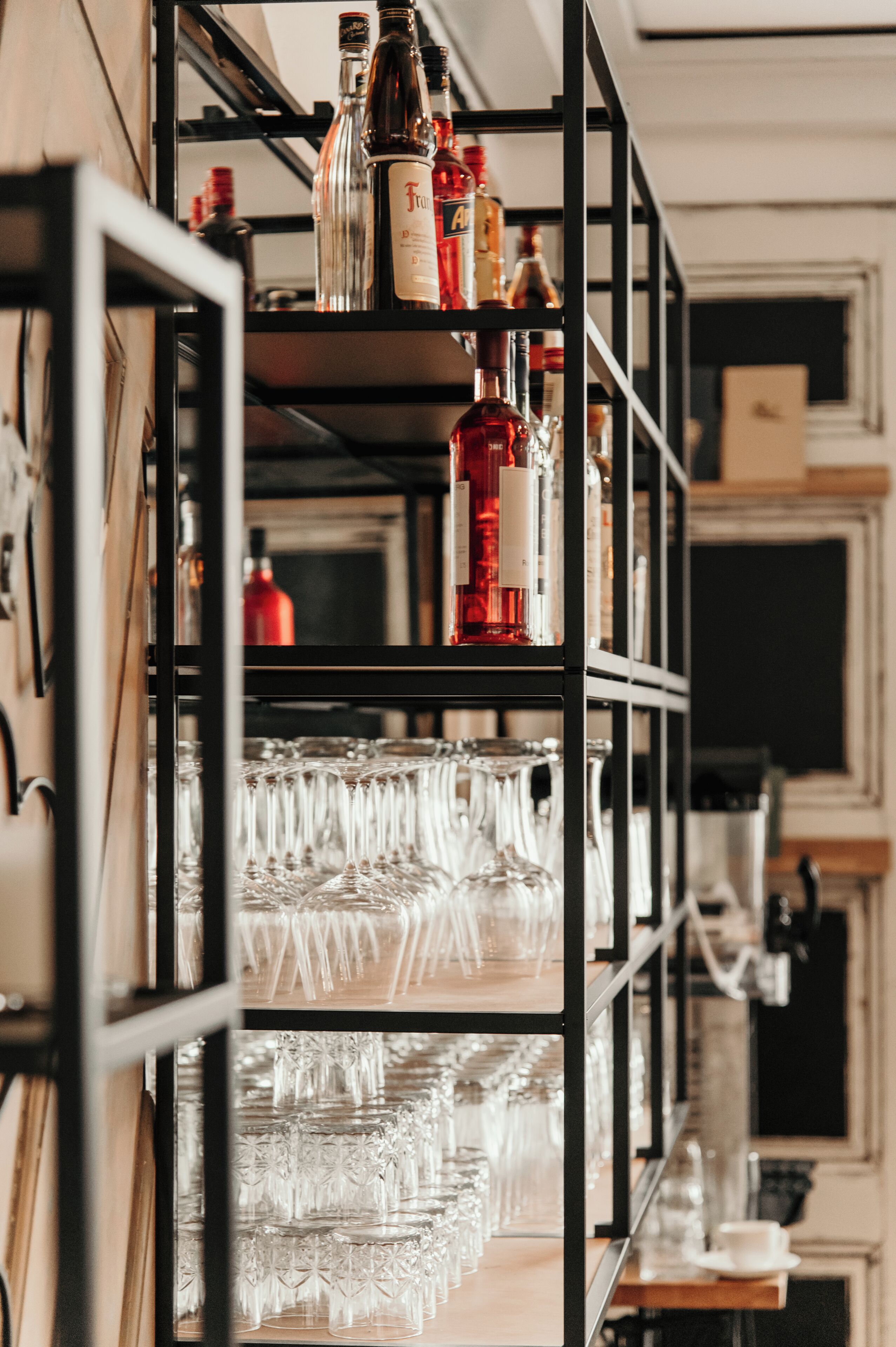 Eine Bar mit Regalen voller Flaschen und Gläsern.