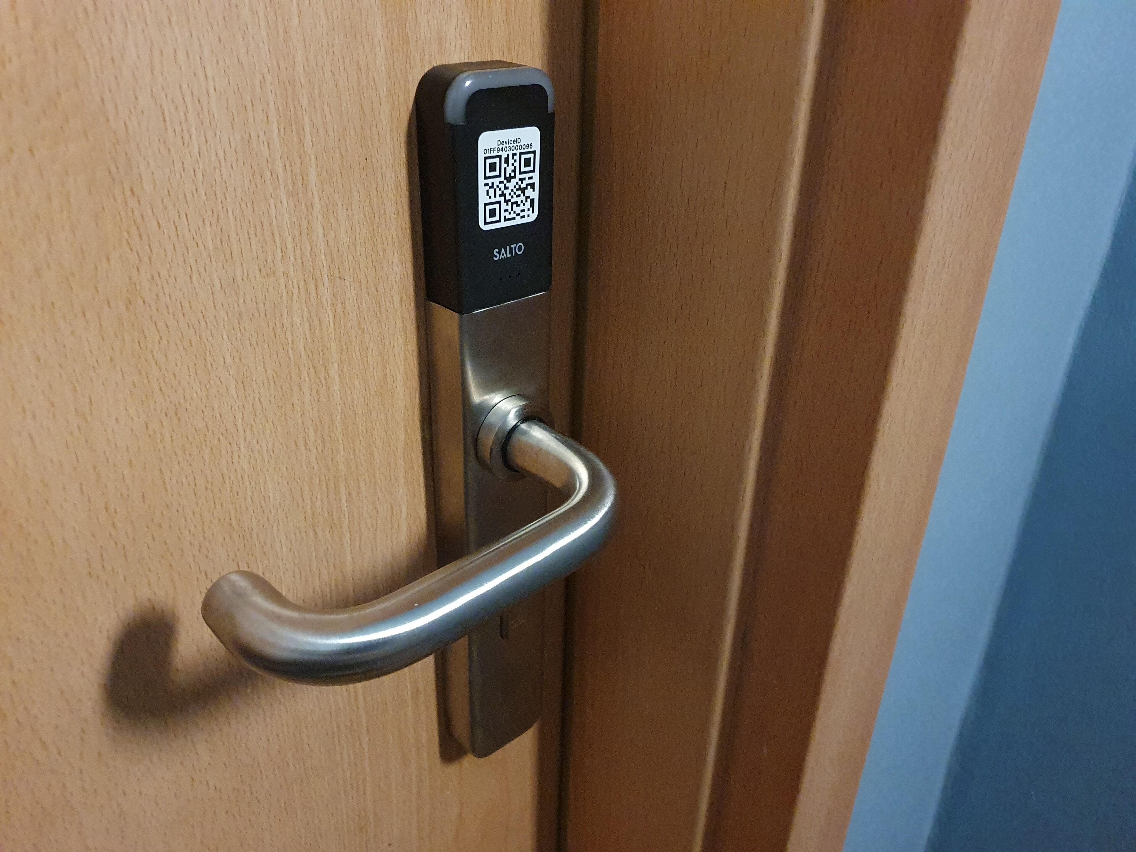 A door with a QR code and a keycard reader.