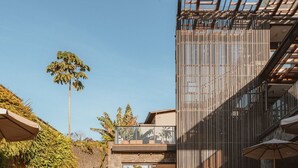 Een modern gebouw met een reflectiebad, een trap en terrasplekken.