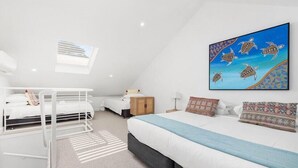 A modern, well-lit bedroom with bunk beds, a large bed, and a vibrant artwork on the wall. - Oceanic Hideaway 18: 1  BR, 1  BA Apartment in Sorrento, Sleeps 4 (Sorrento)