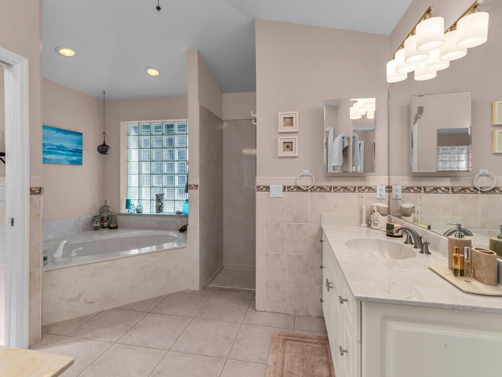 Un baño moderno con bañera, un espejo grande y un mueble de tocador con lavamanos.