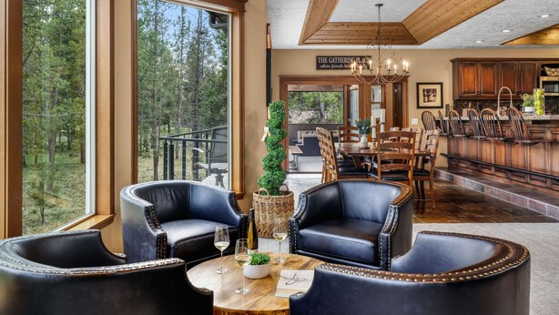 A spacious living area with leather chairs, a wooden table, and a view of the outdoors.