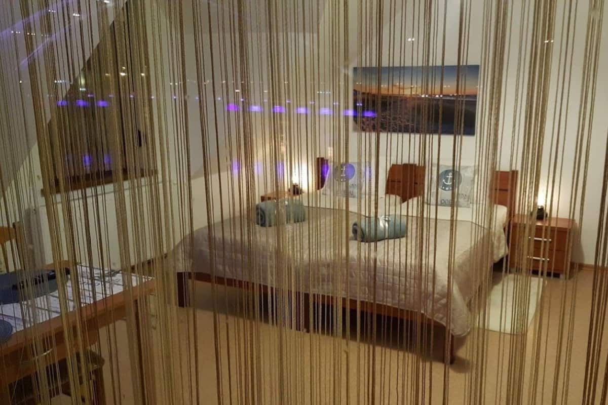 Ein Schlafzimmer mit Bett, Nachttischen, einem Schminktisch und einem Bild an der Wand.