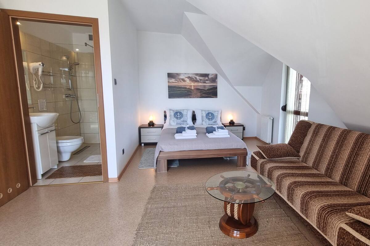 Ein modernes Wohnzimmer mit einer Couch, einem Glastisch und einem Bild an der Wand.