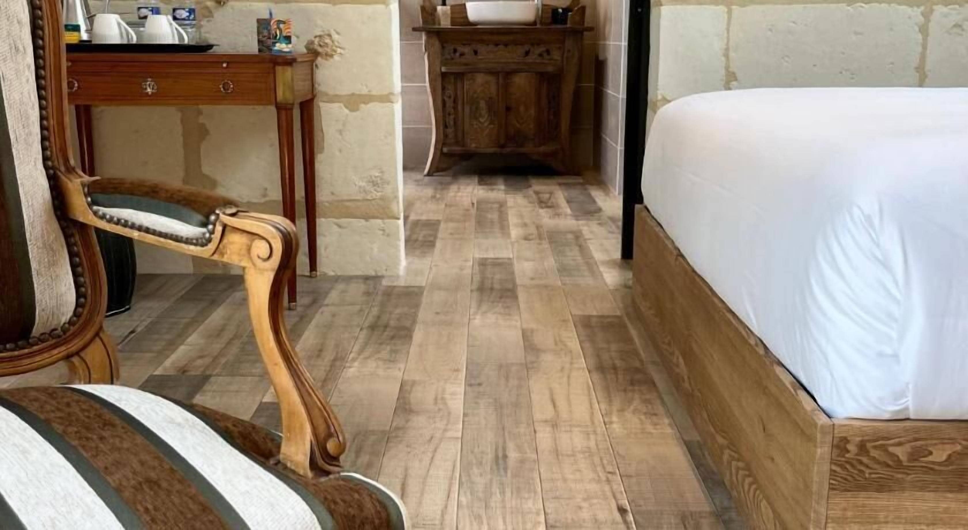 Una camera da letto con un letto e una scrivania in legno, e una sedia.