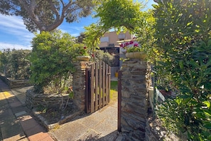 A stone gate leading to a property with a view of a building in the background.