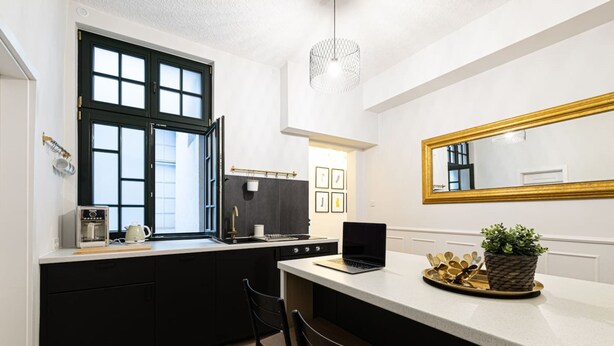 A modern kitchen with a large window, a built-in stove, and a laptop on the counter. - Verde 2 - Spokojny Pok j w Dolnym Mie cie (Gdansk)