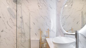 A bathroom with a white marble wall, a white sink, and a toilet. - Madrid Central Stay Plaza Mayor (Madrid)