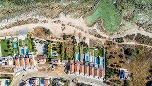 Vue aérienne d’un quartier résidentiel avec de nombreuses maisons, une piscine et une plage.