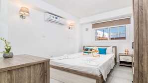 Un dormitorio moderno con una cama de madera, mesitas de noche, un ventanal con vistas y un equipo de aire acondicionado.