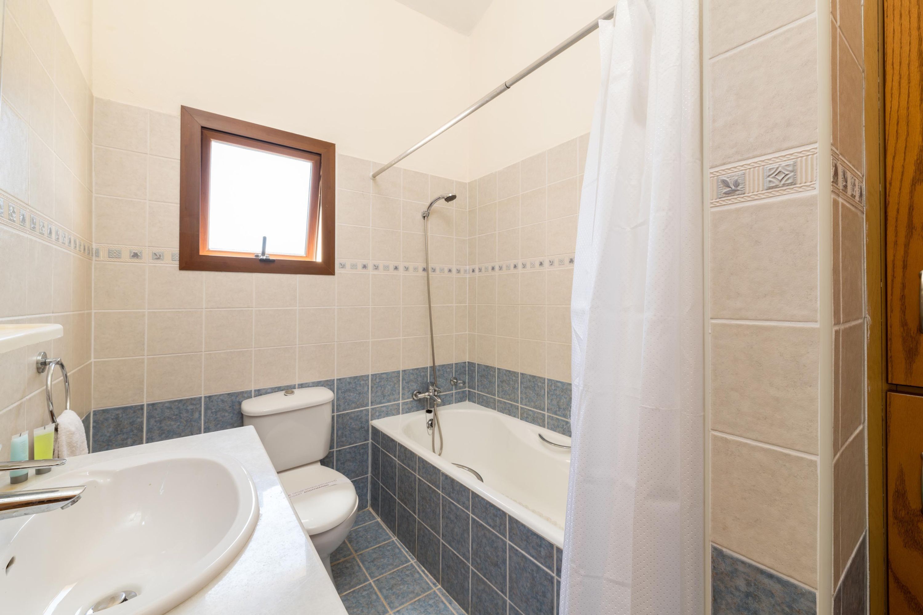 A bathroom with a bathtub, toilet, and sink.