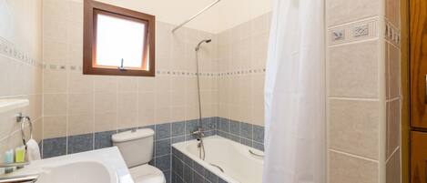A bathroom with a bathtub, toilet, and sink.