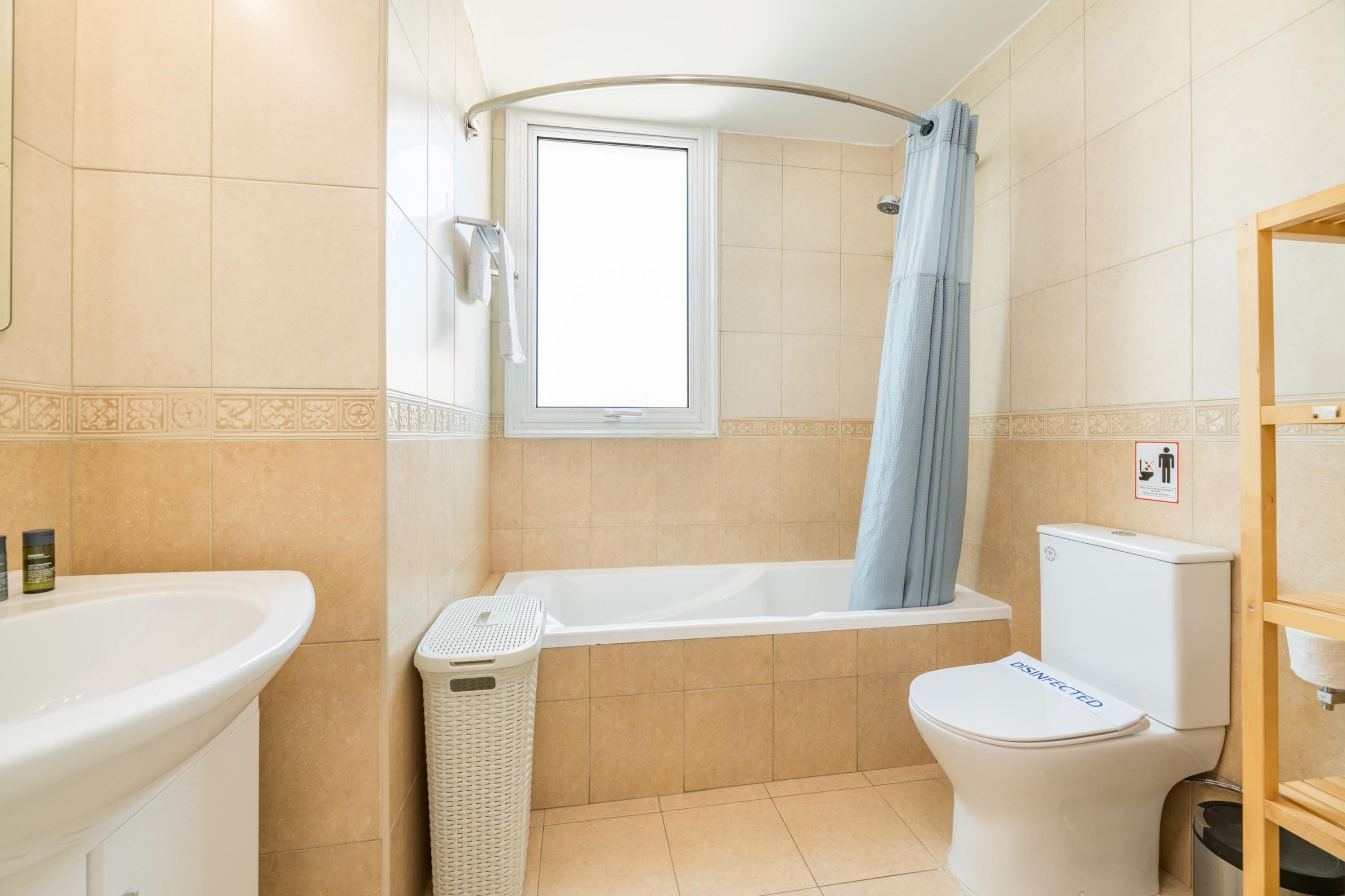 A bathroom with a bathtub, toilet, and sink.