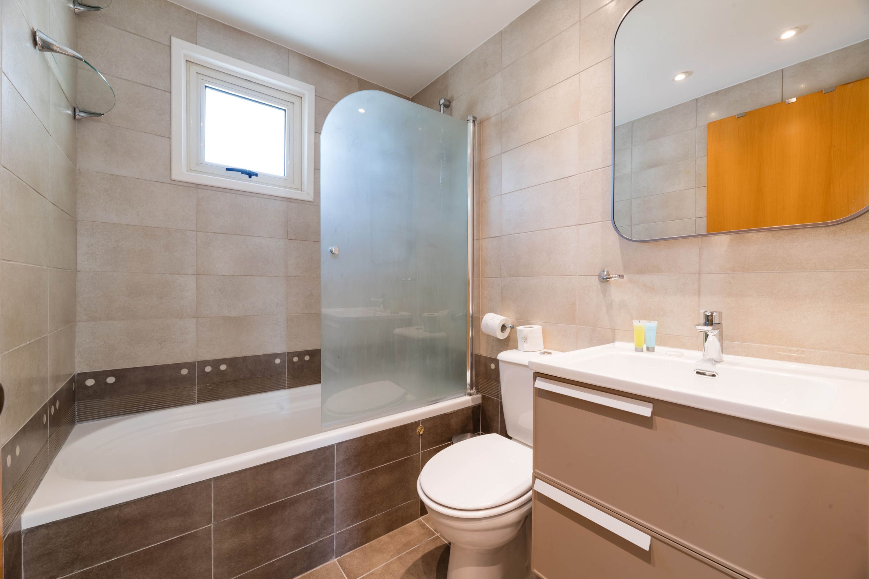 Un baño moderno con bañera, inodoro y tocador.