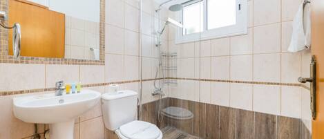 A bathroom with a sink, toilet, and shower.