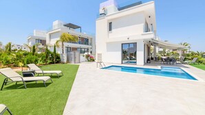 A modern two-story house with a swimming pool, outdoor seating, and a well-maintained lawn. - By The Beach - Emerald Seaview Villa (Paralimni)