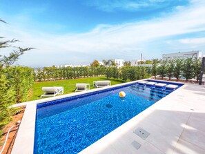 A rectangular swimming pool with clear blue water, surrounded by a tiled deck. - Azure Seaview - Jade Villa (Paralimni)