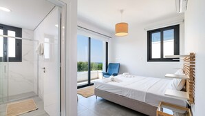 Un dormitorio moderno con una cama, una silla, una mesita de noche y vistas al exterior.