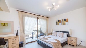 A modern bedroom with a bed, bedside tables, a desk, and a chair. - Villa Greco Mare 20 (Paralimni)