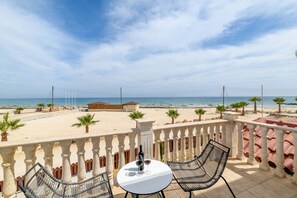 A balcony with a table and chairs overlooking a beach. - Sirens Beach House in Ayia Napa (Sotira)