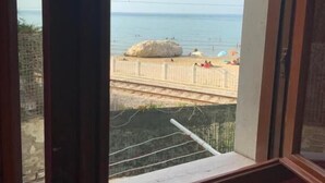Quarto com uma grande janela com vista para a praia.