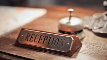 Un mostrador de recepción con un letrero que dice 'RECEPTION' sobre una superficie de madera.