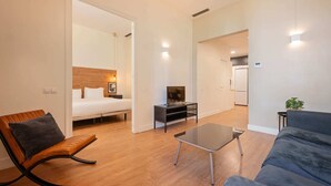 Una camera d'albergo moderna con un letto, una TV, un tavolino da caffè e un divano.