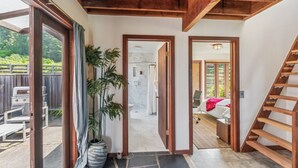 Ein geräumiger Flur mit Holzboden und Blick auf ein Schlafzimmer mit Bett und Treppe.