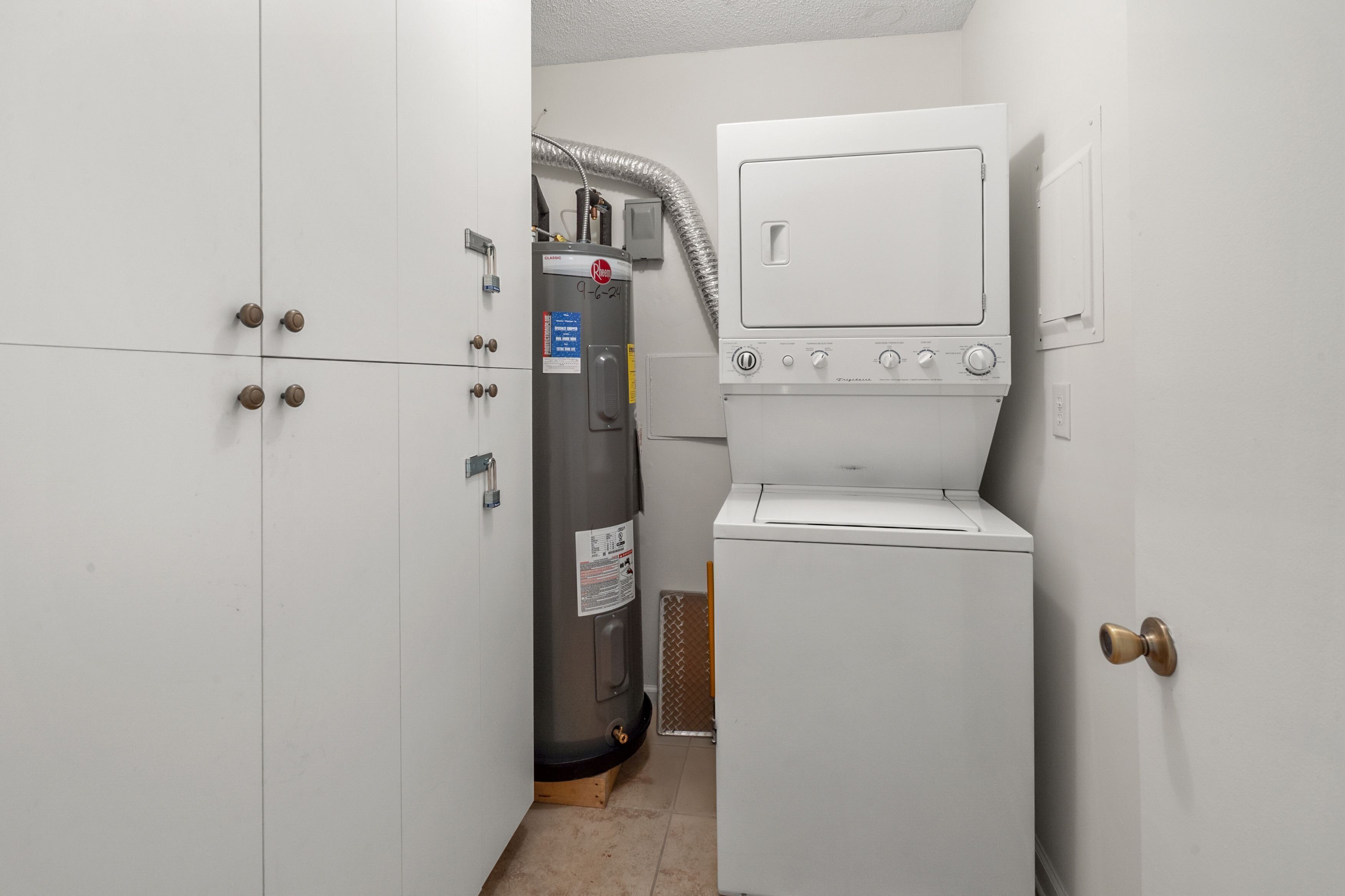 A compact laundry area with a water heater, a washing machine, and a dryer.