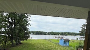 Une terrasse en bois offrant une vue sur un lac et un quai.