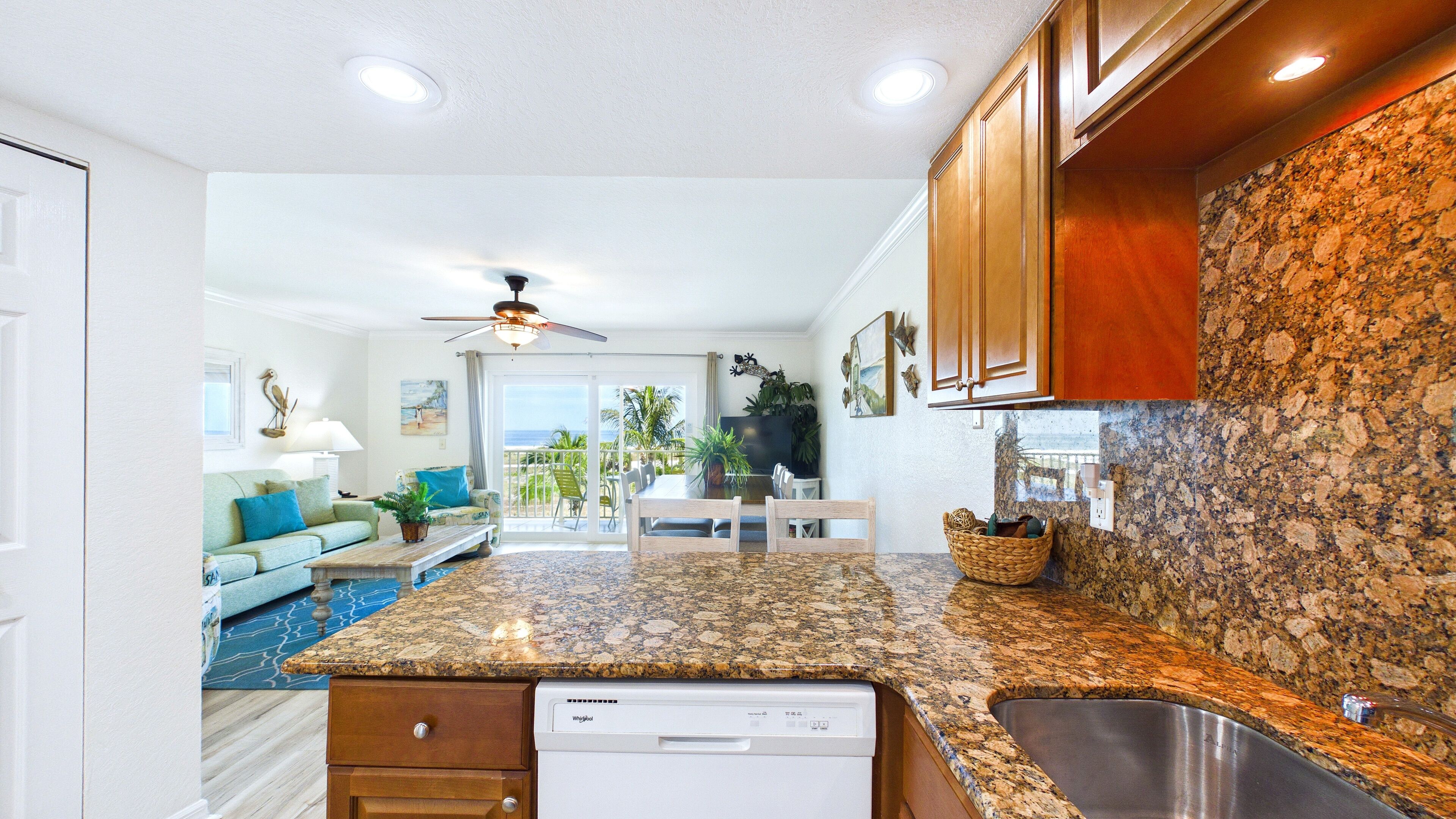A kitchen with granite countertops, wooden cabinets, and a dishwasher.