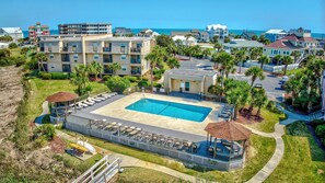 A resort with a swimming pool, multiple buildings, and a beach view. - Two Bedroom Condo with a Shared Swimming Pool on the channel front. (Garden City Beach)