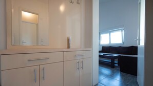 Une salle de bain avec un miroir, des placards et une fenêtre.