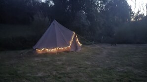 Een tent met lichtjes in een grasveld.