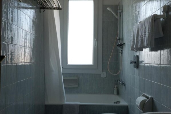 A bathroom with a window, a shower, and a bathtub.