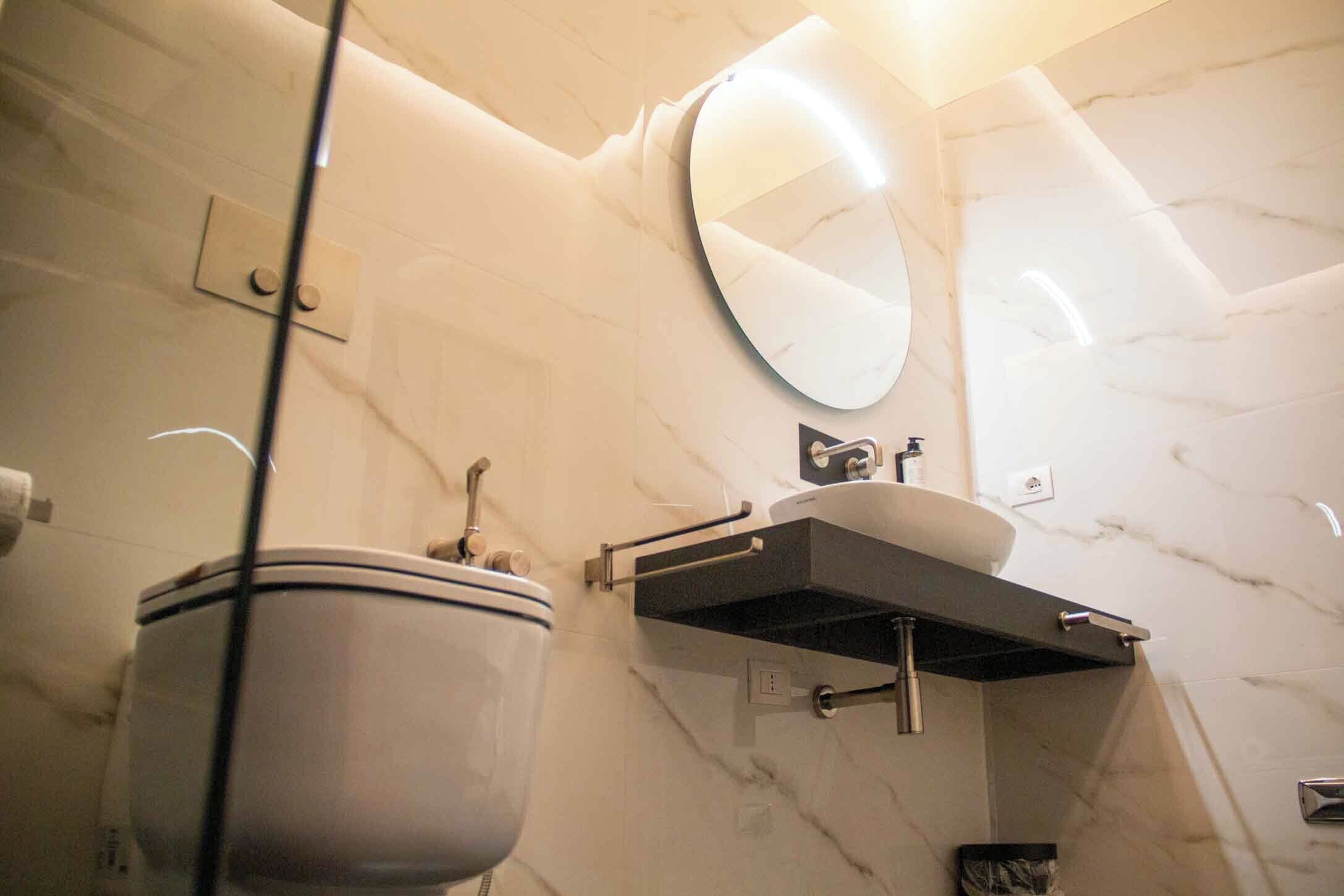 Une salle de bain avec des toilettes, un lavabo et un miroir.