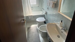 Un baño con bañera, inodoro y lavamanos.