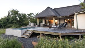 Ein modernes Haus mit Swimmingpool, Sitzgelegenheit im Freien und einer Terrasse.