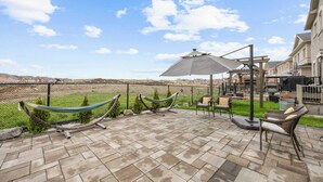 A patio area with a hammock, outdoor furniture, and a view of a residential neighborhood. - Caledon Escape I 7BR Home with BBQ & Backyard (Caledon)