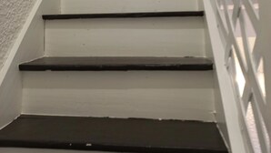 Eine Treppe mit weißen Wänden und einem Metallgeländer.