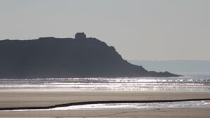 A beach with a large rock formation in the distance. - Stone house 600 m from the sea with garden and terrace. (Plomodiern)