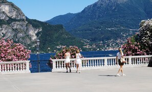 A promenade with a view of a mountainous landscape and a body of water.