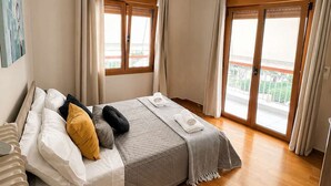 A bedroom with a bed, curtains, a ceiling light, and a view through the window. - Alimos Cozy Getaway, close to the beach (Alimos)