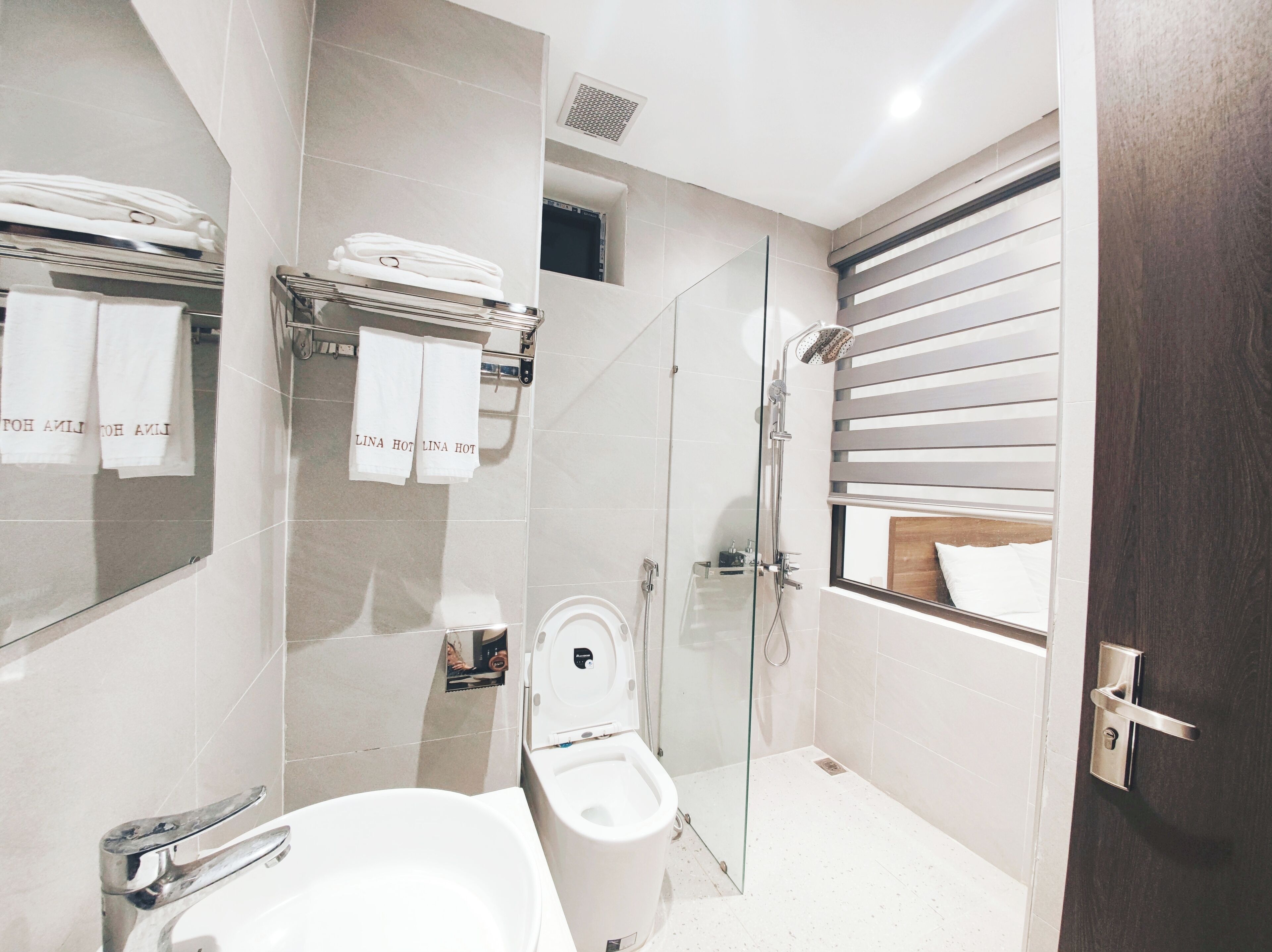 Une salle de bain moderne avec une douche à parois de verre, des toilettes et un lavabo.