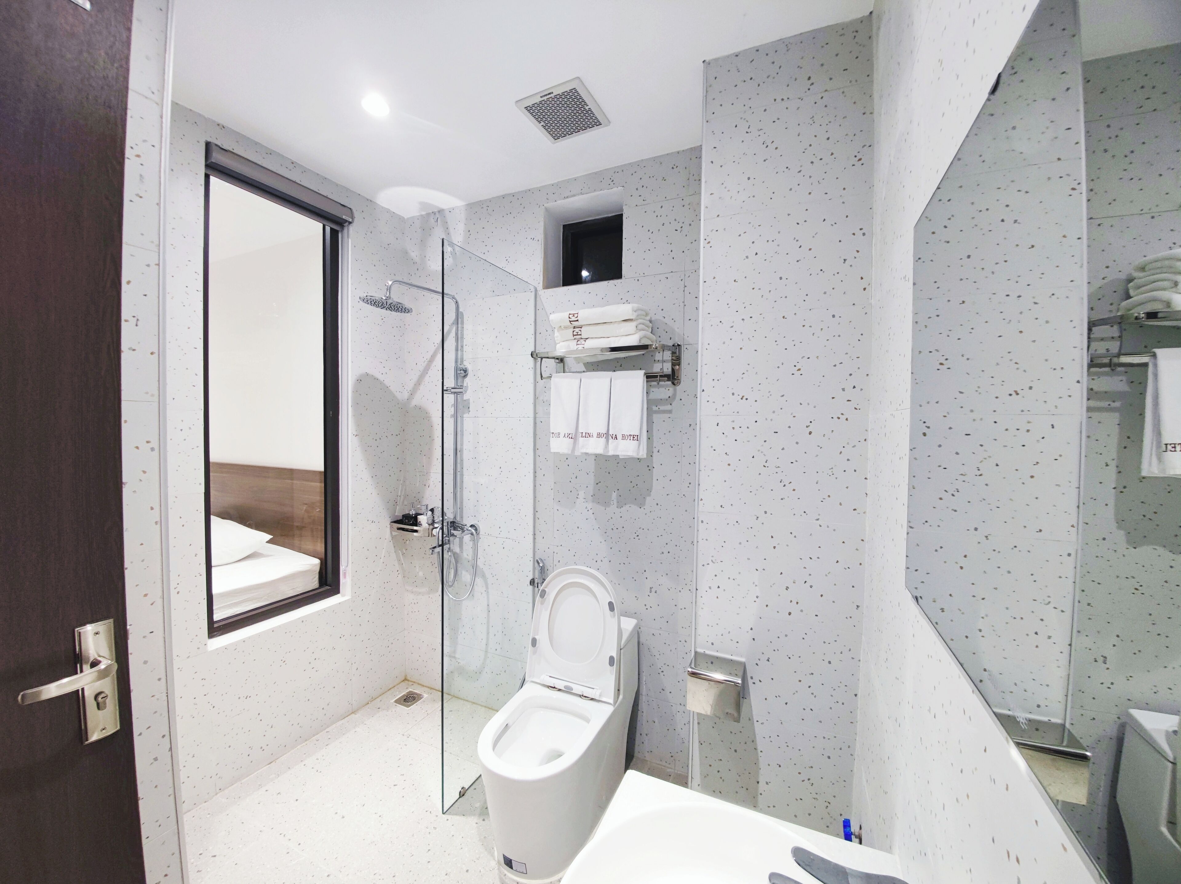 A modern bathroom with a glass-enclosed shower, a toilet, and a bathtub.