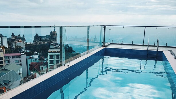 A rooftop pool with a clear view of surrounding buildings and a distant landmark. - Celina Hotel - Khach San Tam Dao (Tam Dao)